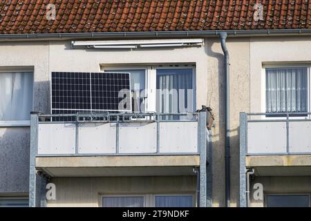 Sonnenkollektoren auf einem Balkon und nicht auf dem Balkongeländer, wahrscheinlich nicht erlaubt vom Vermieter. Stockfoto