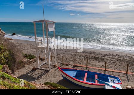 Wachturm und kleines dekoratives Boot am Strand Carabeo in der Gemeinde Nerja. Stockfoto