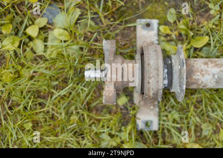 Zentrales Lager und Schale von einer Gelenkwelle. Aus einem Auto entfernt und im Gras gelegen. Rostige Lageraußenfläche und Ende einer Antriebswelle. Stockfoto