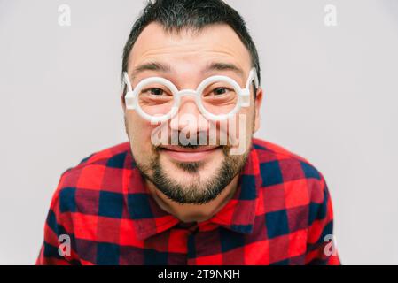 Lustiges Porträt eines Mannes mit Brille. Fröhliche bärtige Wissenschaftsfreaks, die aus nächster Nähe in die Kamera schauen. Сomic Nerd Nahaufnahme Porträt. Stockfoto