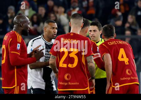 Rom, Italien. November 2023. Schiedsrichter Luca Massimi, Zweiter von rechts, streitet mit Roma und udinesischen Spielern während ihres italienischen Meisterschaftsfußballspiels der Serie A im Olympiastadion in Rom, Italien am 26. November 2023. Quelle: Riccardo De Luca - Update Images/Alamy Live News Stockfoto