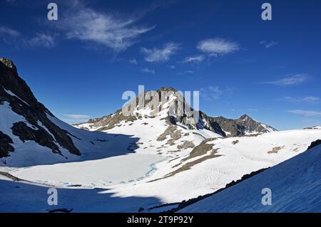 Der Charybdis Mountain erhebt sich im Juli eines Hochschneejahres über einem größtenteils gefrorenen See 11828 im Ionischen Becken des Kings Canyon National Park Stockfoto