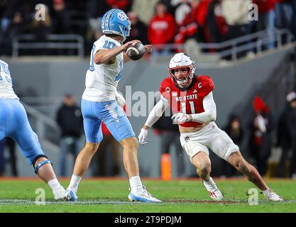 25. November 2023: NC State Senior Payton Wilson (11) drückt North Carolina Sophomore Drake Maye (10). NCAA-Fußballspiel zwischen der University of North Carolina und der NC State University im Carter Finley Stadium, Raleigh, North Carolina. David Beach/CSM Stockfoto