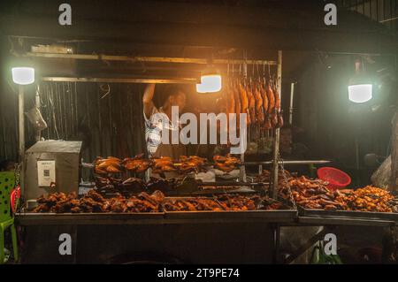 Ein Kambodschaner verkauft während des Kambodschanischen Wasserfestivals in Phnom Penh, Kambodscha, Barbecue-Hühnchen und Enten an einem Straßenstand im Freien. © Kraig Lieb Stockfoto