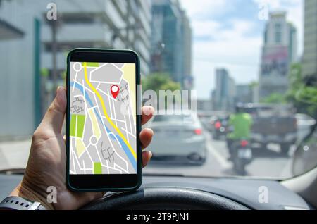 Mann, der ein Mobiltelefon in der App für die Kartensuche verwendet. Navigation der Smartphone-Anwendung, gps-Online-Standortverkehr im Auto. Stockfoto