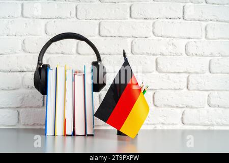 Stapel Bücher und Flagge Deutschlands auf dem Schreibtisch. Deutschsprachenlernkonzept Stockfoto