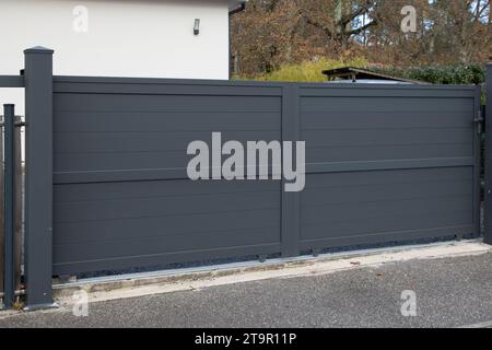 Tür graues Schiebetor Stahl große graue dunkle Metall Schiebetür elektrische Portalzaun an der modernen Fassade Haus Straße Stockfoto