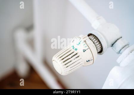 Kühlerthermostat und Hand. Heizhaus im Winter. Einsparungen beim Heizkonzept. Hochwertige Fotos Stockfoto