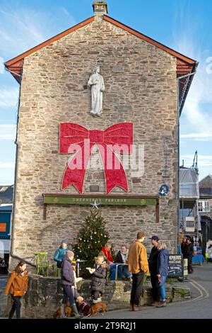 Hey-on-Wye Rathaus mit rotem Bogen, Weihnachtsbaum und Menschen, die auf dem Platz spazieren gehen, während des Buchfestivals des Hay Winter Festivals in Wales, Großbritannien KATHY DEWITT Stockfoto