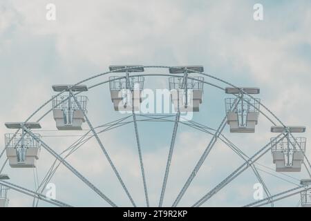 Das Riesenrad für Panoramablick im Vergnügungspark ist beliebte unterhaltsame Fahrt, die am hellen sonnigen Tag am Sommerhimmel gedreht wird, selektiver Fokus Stockfoto