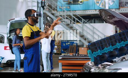 Servicetechniker in der Fahrzeugwartung mit fortschrittlicher Virtual-Reality-Technologie zur Visualisierung der Turbine, um sie zu reparieren. Sachkundiger Werkstattspezialist mit vr-Brille bei der Wartung defekter Fahrzeuge Stockfoto