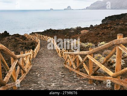 Wunderschöner Weg mit Holzzaun zum Strand Playa Charco los Sargos im Abendlicht bei El Hierro, la frontera, Kanarischen Inseln Stockfoto