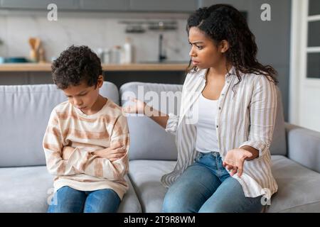 Wütende afroamerikanische Mutter schimpfte den verärgerten kleinen Sohn zu Hause Stockfoto