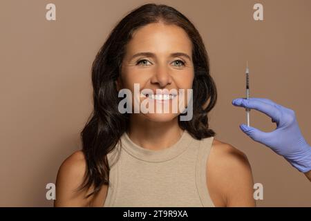 Gute kaukasische alte Dame, genießen Sie Anti-Falten-Behandlung, Kosmetikerin macht Injektion Stockfoto