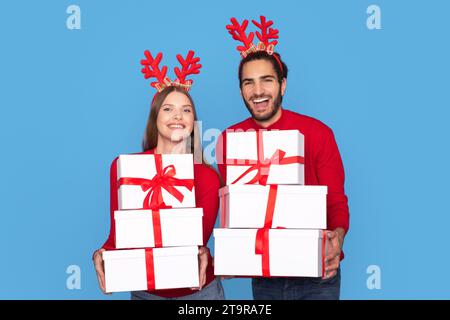 Fröhlicher Mann Und Frau In Rentier Party Geweih Mit Geschenkboxen Stockfoto