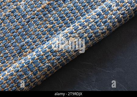 Handgewebter Teppich mit geometrischem Denim-Bereich auf schwarzem Boden. Stockfoto