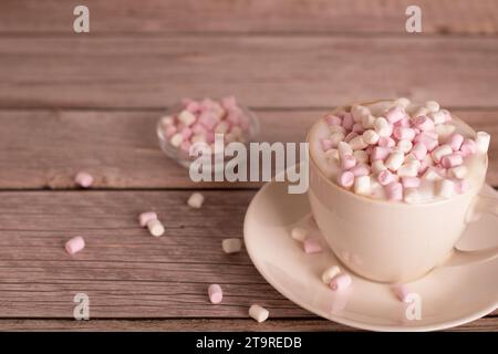 Foto süßes Dessert, weißes und rosa Marshmallow liegt in einer Tasse Kaffee mit Schaum, Nahaufnahme, es gibt einen leeren Raum, lecker, warm, Süßigkeiten, Tisch, Snack Stockfoto