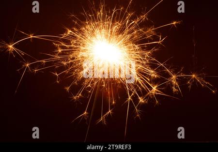 Foto auf diesem horizontalen Weihnachtsfoto strahlt ein lebhafter bengalischer Funkler ein festliches Leuchten aus. Das strahlende Licht verleiht dem Besucher einen Hauch von Weihnachtszauber Stockfoto
