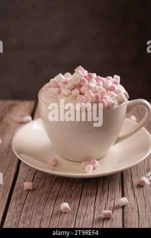 Foto süßes Dessert, weißes und rosafarbenes Marshmallow, Tasse Kaffee mit Schaum, Minimalismus, Genuss, aromatisch, Objekt, wärmend, vertikal Stockfoto