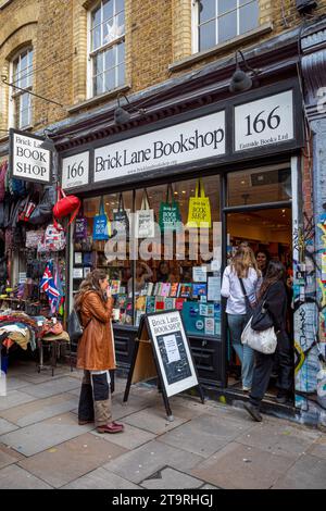 Brick Lane Bookshop in Brick Lane im Londoner East End. Kunden, die den Brick Lane Bookshop in 166 Brick Lane Shoreditch East London betreten. Stockfoto