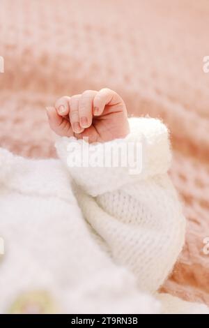 Nahaufnahme einer kleinen, neugeborenen Mädchenhand auf rosa Decke Stockfoto