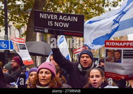 London, Großbritannien. November 2023. Ein Demonstrant hält während der Demonstration ein Schild mit der Aufschrift „nie wieder ist jetzt“. Tausende pro-israelische Demonstranten marschierten in Zentral-London gegen den Antisemitismus und forderten die Freilassung israelischer Geiseln, die von der Hamas in Gaza festgehalten wurden. (Foto: Vuk Valcic/SOPA Images/SIPA USA) Credit: SIPA USA/Alamy Live News Stockfoto