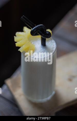 Ein Glas Smoothie auf einem Tisch, ein Stück Obst auf dem Glas, Black Drinking Starw. Stockfoto