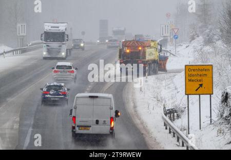 27. November 2023, Rheinland-Pfalz, Meilbrück: Autos und ein Streuwagen auf der Straße im Fahrschnee auf der B51. Am Morgen schneite es bis in die Tiefebene in Rheinland-Pfalz. Der Verkehr war vielerorts behindert. Foto: Harald Tittel/dpa Stockfoto