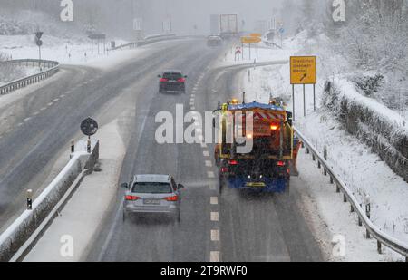 27. November 2023, Rheinland-Pfalz, Meilbrück: Autos und ein Streuwagen auf der Straße im Fahrschnee auf der B51. Am Morgen schneite es bis in die Tiefebene in Rheinland-Pfalz. Der Verkehr war vielerorts behindert. Foto: Harald Tittel/dpa Stockfoto