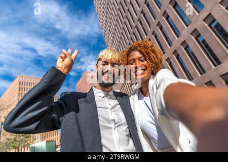 Frontales Nahporträt zweier junger multiethnischer Geschäftsleute, die draußen ein Selfie machen Stockfoto