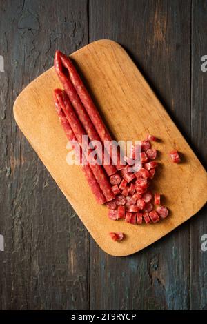 Kleine dünne geräucherte Würstchen auf einem Brett geschnitten Stockfoto