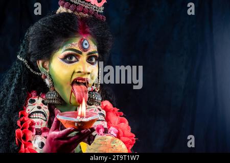 Porträt des wunderschönen indischen Mädchens von Durga Idol Agomoni Konzept Innenfoto mit traditionellem indischem Saree, Goldschmuck und Armreifen. Maa Durga. Stockfoto