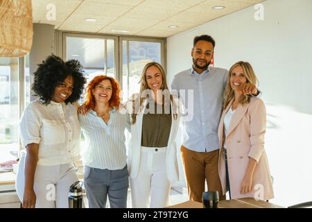 Multiethnische Geschäftsteams lächeln, während sie zusammen im Büro stehen. Geschäftskonzept. Stockfoto
