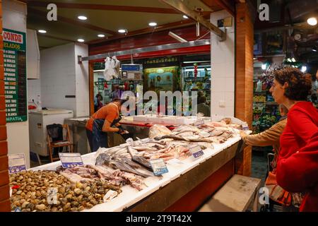 Fischhändler, der Fisch für Kunden in Triana Market, Sevilla, Andalusien, Spanien zubereitet Stockfoto