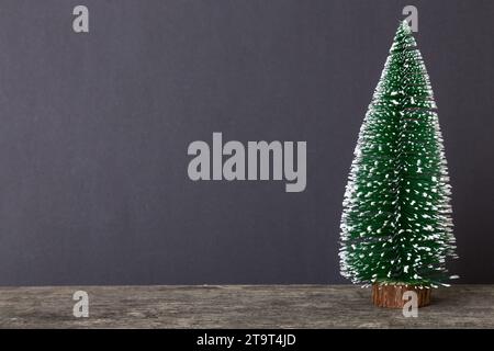 Ein kleiner Weihnachtsbaum auf farbigem Hintergrund. Neujahr Dekoration mit Kopierraum. Stockfoto