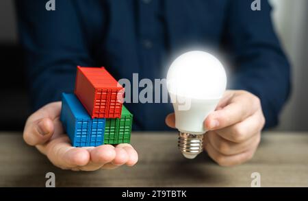 Versandbehälter und eine Idee-Glühbirne in den Händen. High-Tech-Waren und -Produkte. Mehrwert. Innovation und Technologie. Intelligente Container, ausgestattet Stockfoto