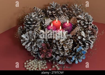 Vier Adventskerzen, Rosenkranz und Adventskranz. Adventskonzept. Stockfoto