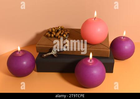 Vier Adventskerzen, Rosenkranz und Gebetsbücher. Adventskonzept. Stockfoto