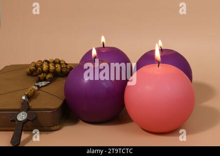 Vier Adventskerzen, Rosenkranz und Gebetsbuch. Adventskonzept. Stockfoto