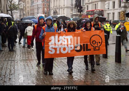 London, Großbritannien. November 2023. Just Stop Oil Demonstranten protestierten heute wieder in London. Sie begannen ihren Protest am Trafalgar Square und hielten dann vor der Downing Street an. Als sie versuchten, auf der Straße gegenüber dem Unterhaus zu sitzen, wurden sie schnell von der Met Police verhaftet und mit Handschellen gefesselt. Alle fünf Demonstranten wurden in Polizeiwagen mitgenommen. Die Höchststrafe für die vorsätzliche Blockierung einer Autobahn in England und Wales beträgt 51 Wochen Haft. Straftäter können ebenfalls mit Geldstrafen belegt werden. Quelle: Maureen McLean/Alamy Live News Stockfoto