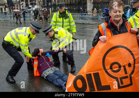 London, Großbritannien. November 2023. Just Stop Oil Demonstranten protestierten heute wieder in London. Sie begannen ihren Protest am Trafalgar Square und hielten dann vor der Downing Street an. Als sie versuchten, auf der Straße gegenüber dem Unterhaus zu sitzen, wurden sie schnell von der Met Police verhaftet und mit Handschellen gefesselt. Alle fünf Demonstranten wurden in Polizeiwagen mitgenommen. Die Höchststrafe für die vorsätzliche Blockierung einer Autobahn in England und Wales beträgt 51 Wochen Haft. Straftäter können ebenfalls mit Geldstrafen belegt werden. Quelle: Maureen McLean/Alamy Live News Stockfoto