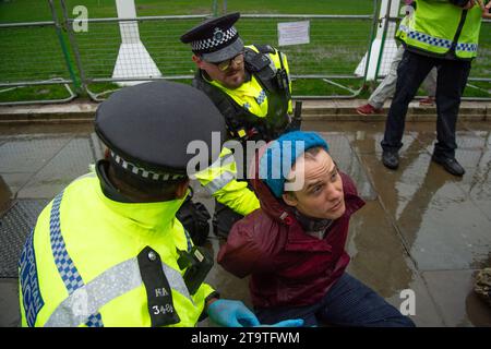 London, Großbritannien. November 2023. Just Stop Oil Demonstranten protestierten heute wieder in London. Sie begannen ihren Protest am Trafalgar Square und hielten dann vor der Downing Street an. Als sie versuchten, auf der Straße gegenüber dem Unterhaus zu sitzen, wurden sie schnell von der Met Police verhaftet und mit Handschellen gefesselt. Alle fünf Demonstranten wurden in Polizeiwagen mitgenommen. Die Höchststrafe für die vorsätzliche Blockierung einer Autobahn in England und Wales beträgt 51 Wochen Haft. Straftäter können ebenfalls mit Geldstrafen belegt werden. Quelle: Maureen McLean/Alamy Live News Stockfoto