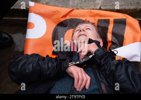 London, Großbritannien. November 2023. Just Stop Oil Demonstranten protestierten heute wieder in London. Sie begannen ihren Protest am Trafalgar Square und hielten dann vor der Downing Street an. Als sie versuchten, auf der Straße gegenüber dem Unterhaus zu sitzen, wurden sie schnell von der Met Police verhaftet und mit Handschellen gefesselt. Alle fünf Demonstranten wurden in Polizeiwagen mitgenommen. Die Höchststrafe für die vorsätzliche Blockierung einer Autobahn in England und Wales beträgt 51 Wochen Haft. Straftäter können ebenfalls mit Geldstrafen belegt werden. Quelle: Maureen McLean/Alamy Live News Stockfoto