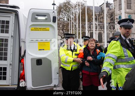 London, Großbritannien. November 2023. Just Stop Oil Demonstranten protestierten heute wieder in London. Sie begannen ihren Protest am Trafalgar Square und hielten dann vor der Downing Street an. Als sie versuchten, auf der Straße gegenüber dem Unterhaus zu sitzen, wurden sie schnell von der Met Police verhaftet und mit Handschellen gefesselt. Alle fünf Demonstranten wurden in Polizeiwagen mitgenommen. Die Höchststrafe für die vorsätzliche Blockierung einer Autobahn in England und Wales beträgt 51 Wochen Haft. Straftäter können ebenfalls mit Geldstrafen belegt werden. Quelle: Maureen McLean/Alamy Live News Stockfoto