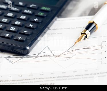 Finanzdiagramm und Diagramm in der Nähe des Stifts und des Rechners in der Finanzzeitung Stockfoto