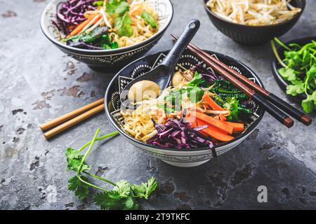 Vegane Miso-Nudelsuppe mit Pilzen, Rotkohl, Karotten und Sprossen Stockfoto