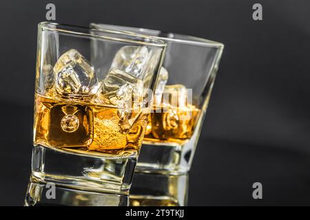 Zwei Gläser Whiskey mit Eiswürfeln auf dunklem Hintergrund, Zeit der Entspannung mit Whisky Stockfoto