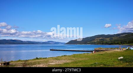 Anfang September, wenn man den Loch Fyne in Nordosten überblickt, entspannen sich einige Leute am Strand von Otter Ferry, Argyll Stockfoto