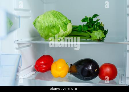 Frisches Gemüse liegt auf dem Regal im Kühlschrank. Lagerkonzept für frisches Gemüse. Stockfoto