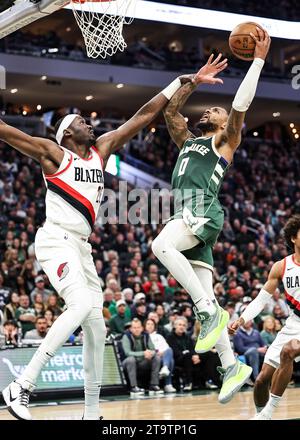 Milwaukee, USA. November 2023. Damian Lillard (R) von Milwaukee Bucks fährt während des regulären NBA-Saisonspiels 2023-2024 zwischen den Milwaukee Bucks und den Portland Trail Blazers in Milwaukee, USA, am 26. November 2023 in den Korb. Quelle: Joel Lerner/Xinhua/Alamy Live News Stockfoto